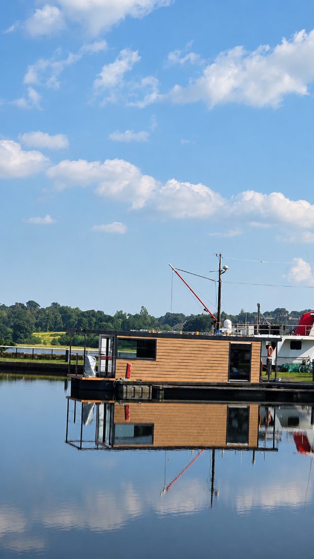 A houseboat on the canal at Bowling, reflected in still water